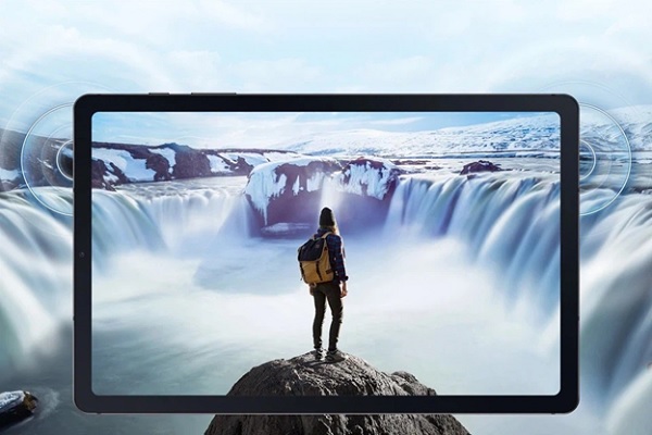 A person standing on a rock looking at a waterfall

Description automatically generated