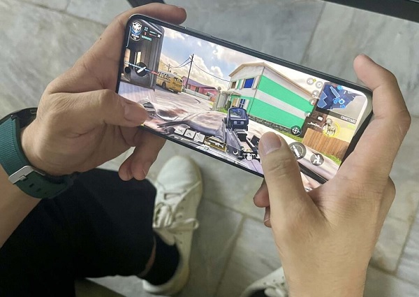 A person holding a phone with a video game on screen

Description automatically generated