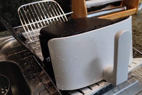 A black and white toaster on a rack

Description automatically generated