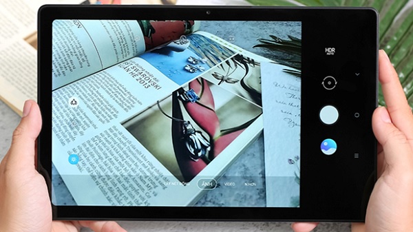 A hand holding a tablet with a book on it
Description automatically generated