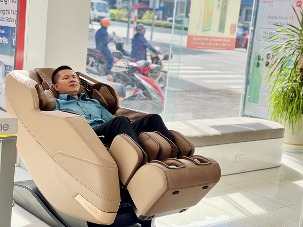 A person in a kimono next to a massage chair
Description automatically generated