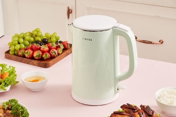 A white kettle on a table with fruit

Description automatically generated