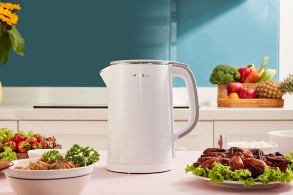 A white kettle on a table with food on it

Description automatically generated