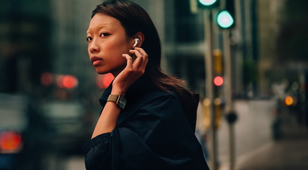 A person with earbuds on her ear

Description automatically generated